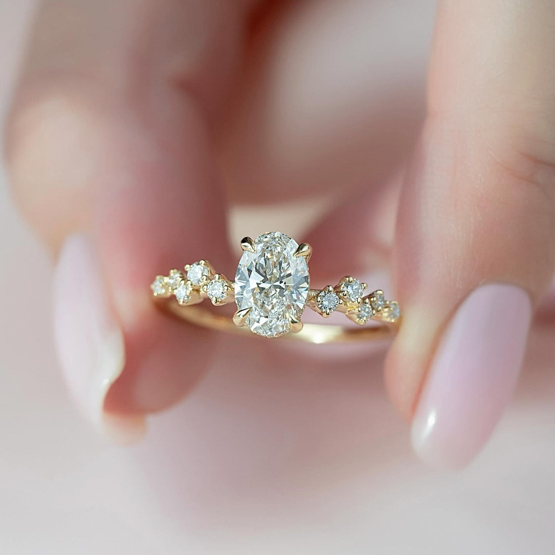 Oval cut lab grown diamond ring in yellow gold with scattered cluster accents on a fine band