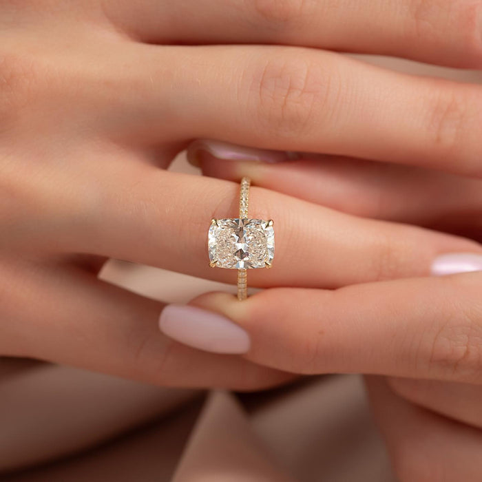 Pave set shoulders meeting the claws of the cushion cut ring