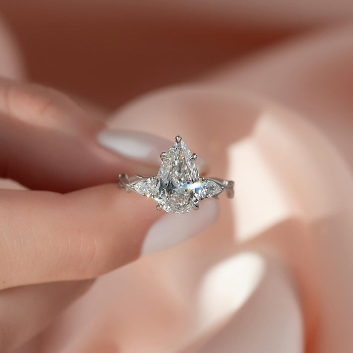 Pear cut lab grown diamond three stone ring with pear side stones on a twig band