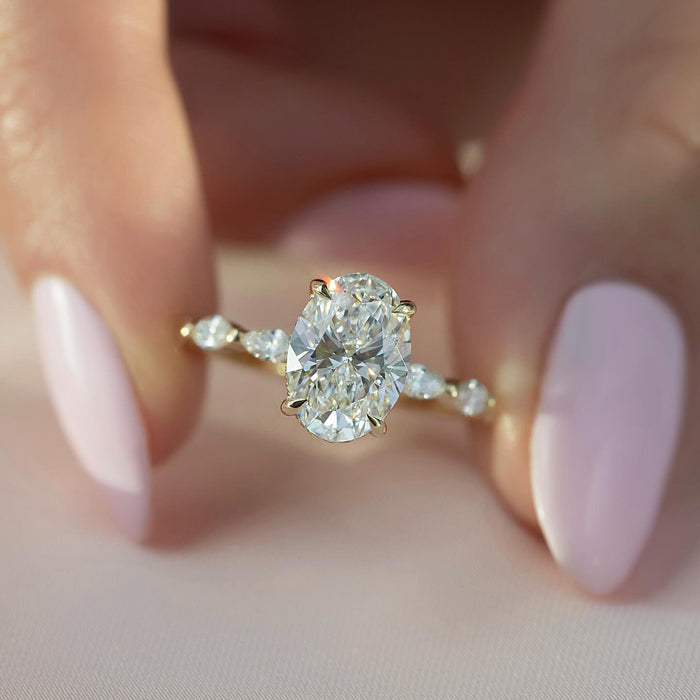Profile view showing the concealed halo beneath the oval diamond and the marquise accents along the shank