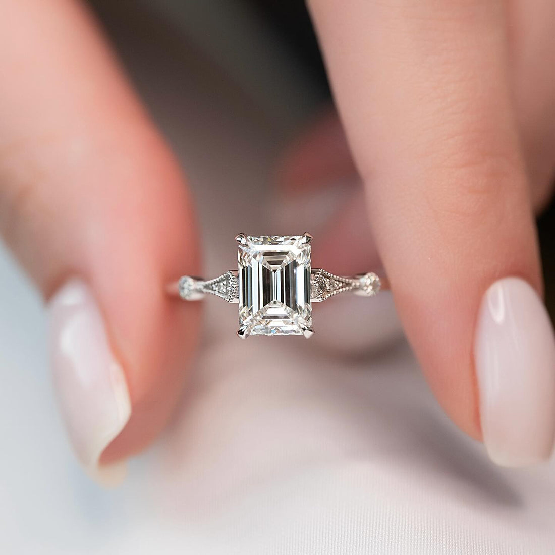 Emerald cut lab grown diamond ring in white gold with milgrain kite shoulders set with small diamonds
