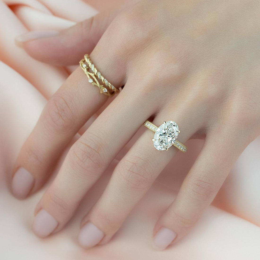 Oval cut lab grown diamond ring with full pave eternity shank in yellow gold worn on the hand