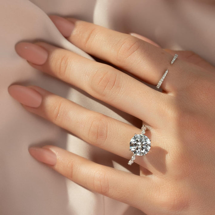 Graduated accents spaced along the shoulders of the round diamond ring