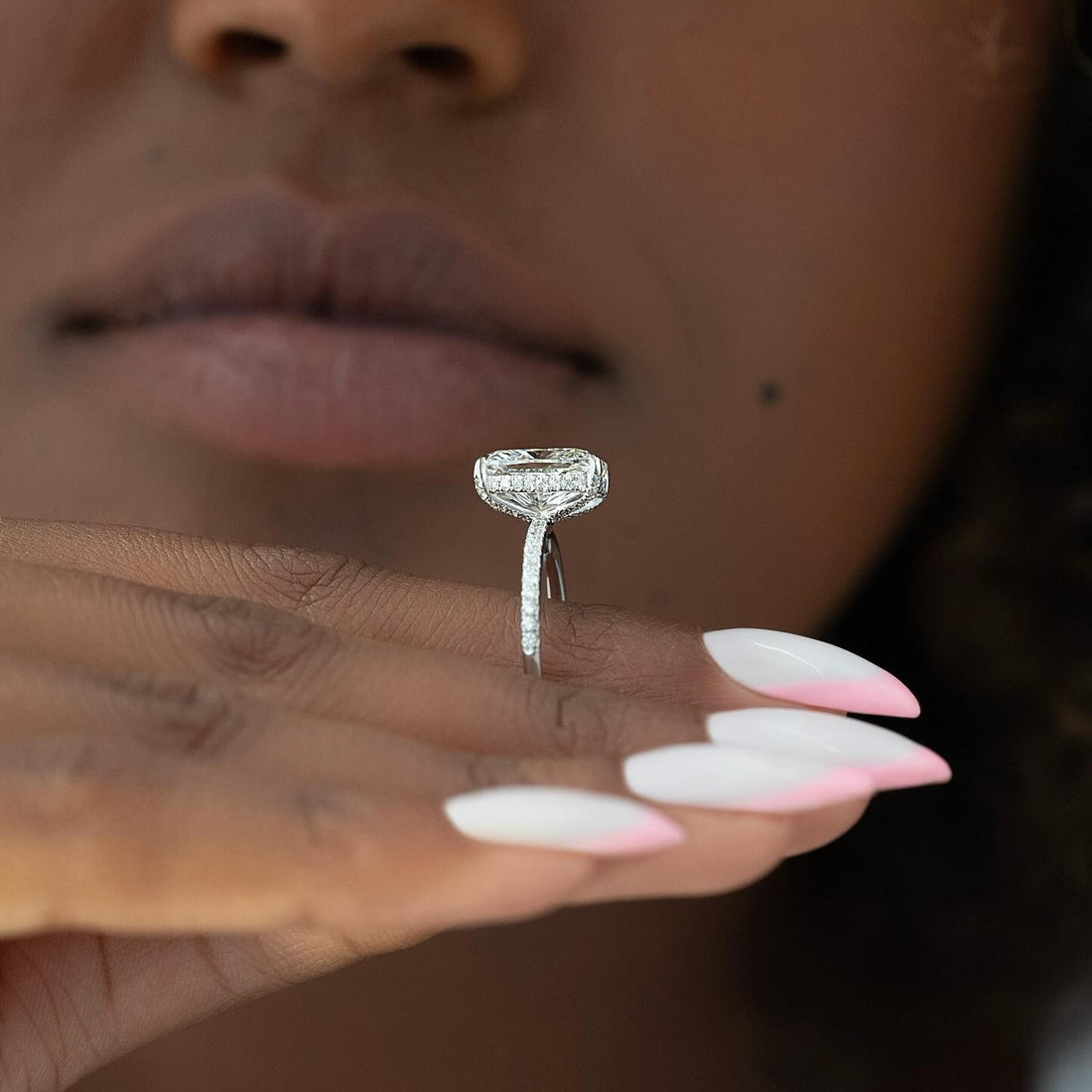 Elongated radiant cut lab grown diamond ring with a wrapped hidden halo on a full pave white gold shank