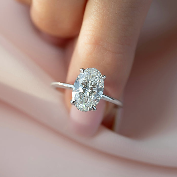 Hidden halo pave wrapping the basket beneath the round diamond