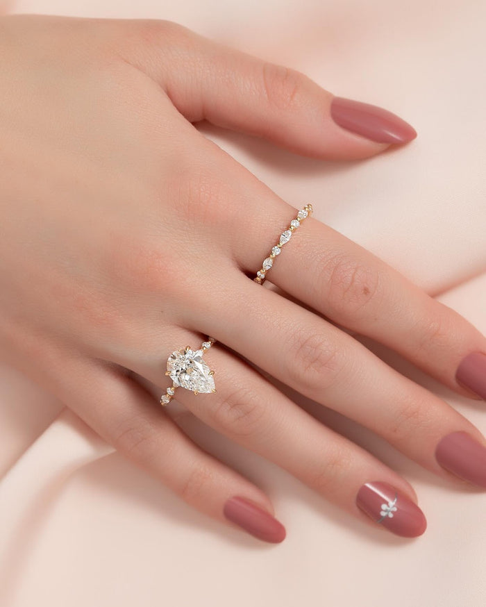 Pear cut lab grown diamond ring with widely spaced floating diamond accents in yellow gold