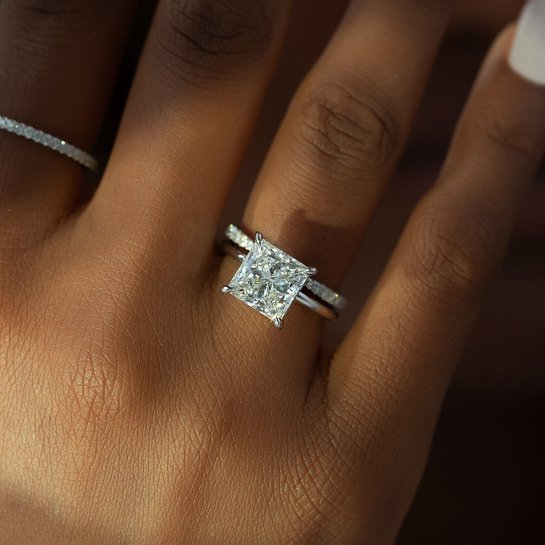 Princess cut lab grown diamond solitaire ring on a slim pave white gold band