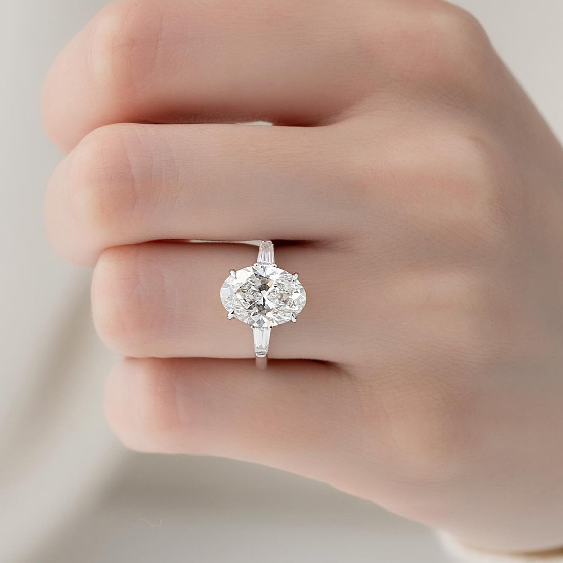 East west oval cut lab grown diamond ring in white gold with upright tapered baguette sides
