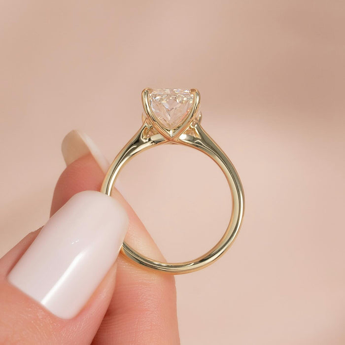 Profile of the radiant cut solitaire showing the open gallery and tapered thin shank