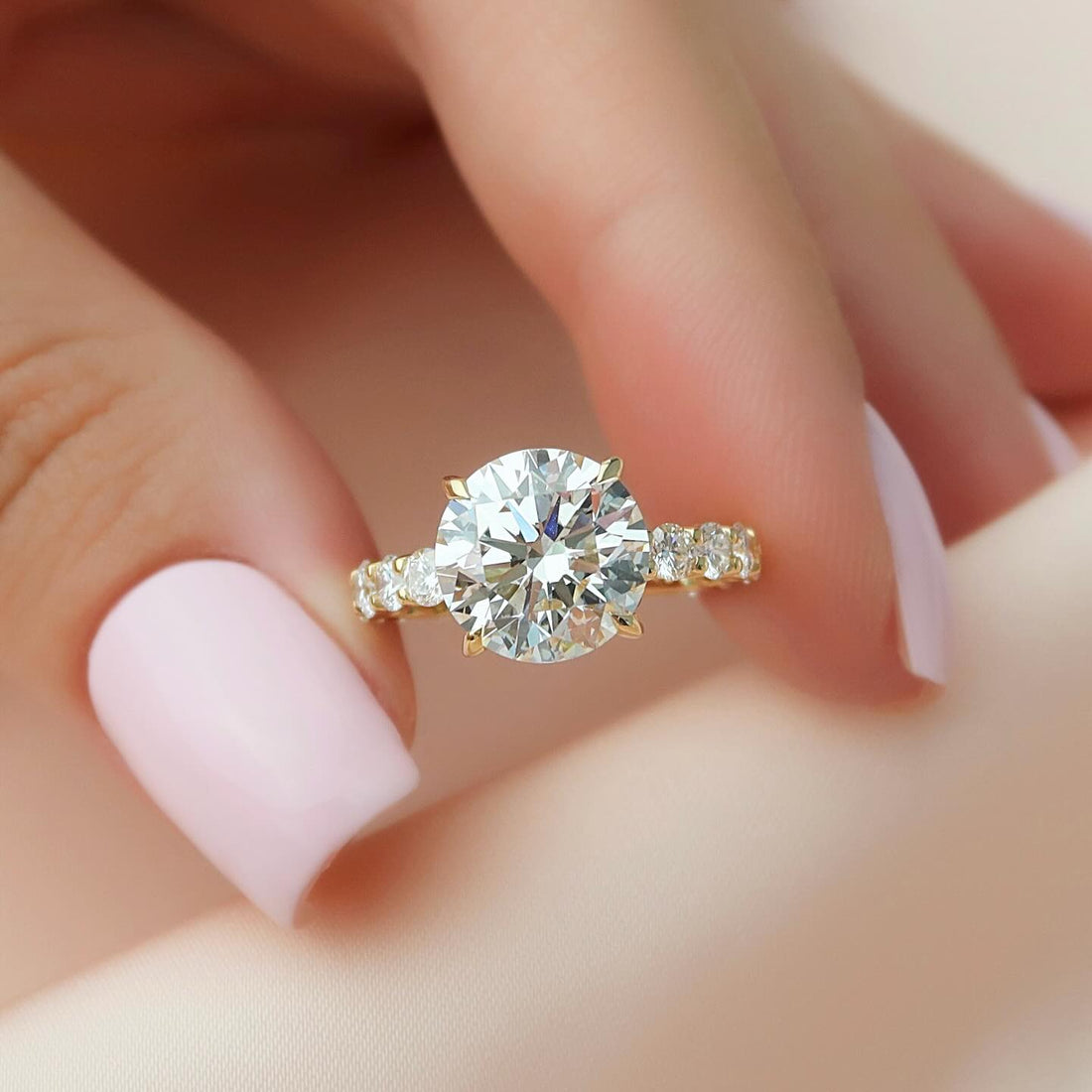 Round lab grown diamond ring with shared prong accent shoulders in yellow gold