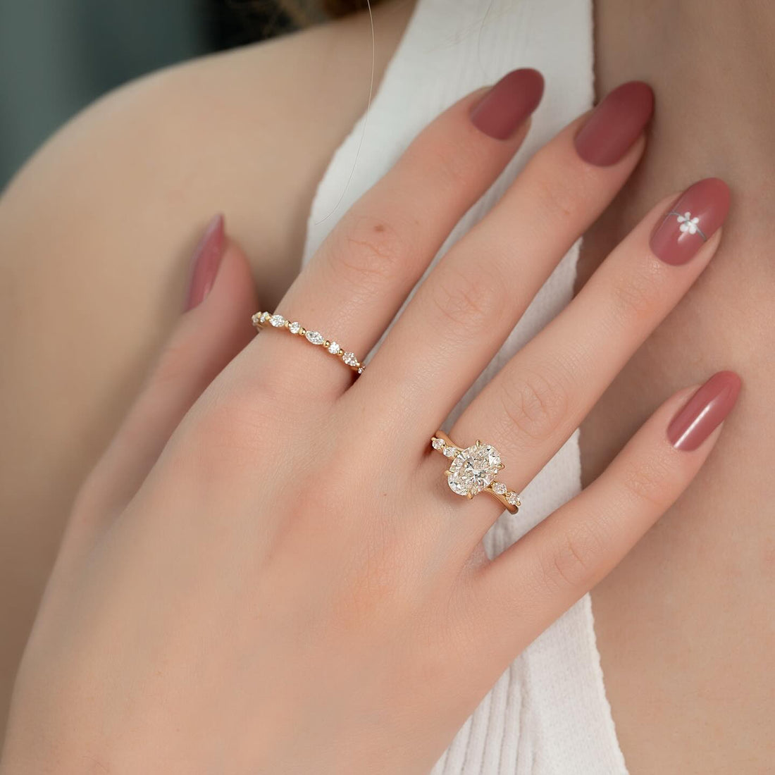 Oval cut lab grown diamond ring with diamond cluster shoulders in yellow gold