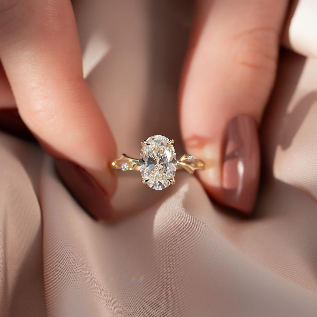 Oval cut lab grown diamond ring with bow shaped shoulders in yellow gold