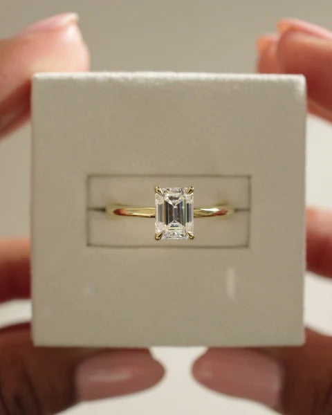 Emerald cut lab grown diamond four claw solitaire ring on plain band