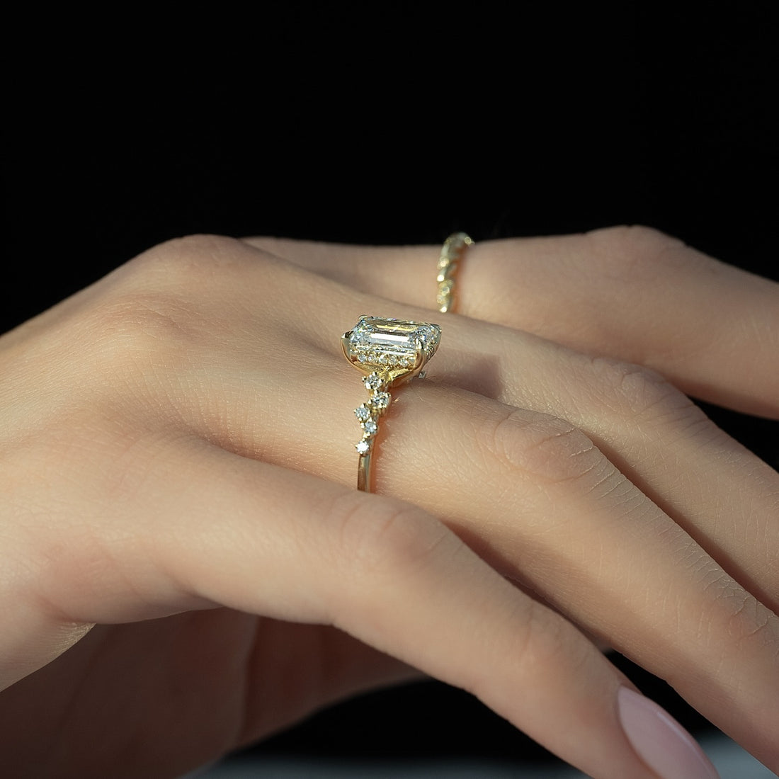Emerald cut lab grown diamond ring with hidden halo and scattered cluster shoulders in yellow gold