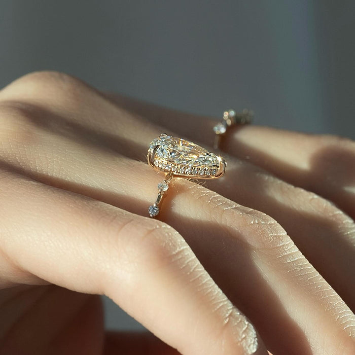 Pear diamond engagement ring in rose gold worn on the hand