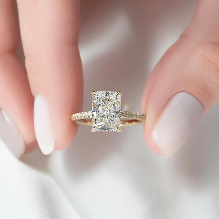 Elongated radiant lab grown diamond ring on a fine pave yellow gold band