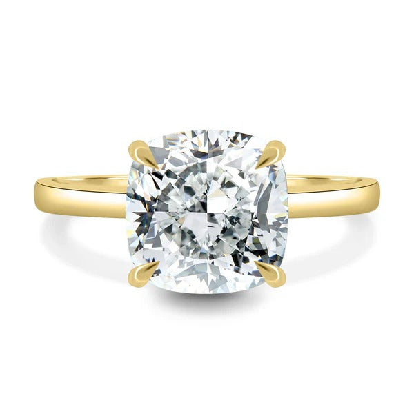 Cushion cut lab grown diamond four claw solitaire ring on a plain flat band