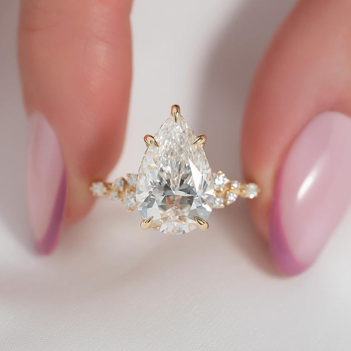 Pear cut lab grown diamond ring with scattered diamond shoulders in yellow gold, front view