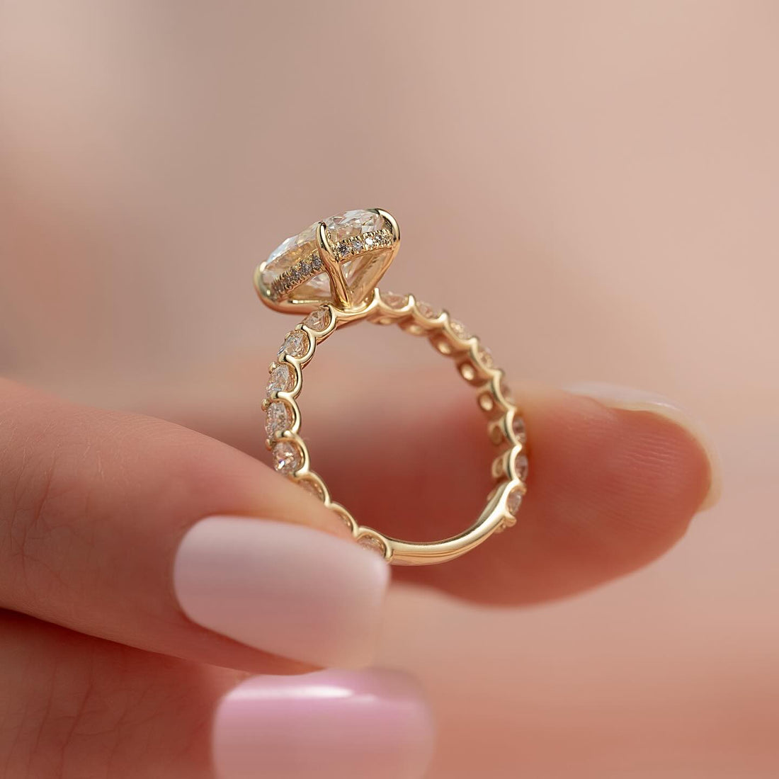 Oval lab grown diamond ring with hidden halo on a shared prong yellow gold diamond band