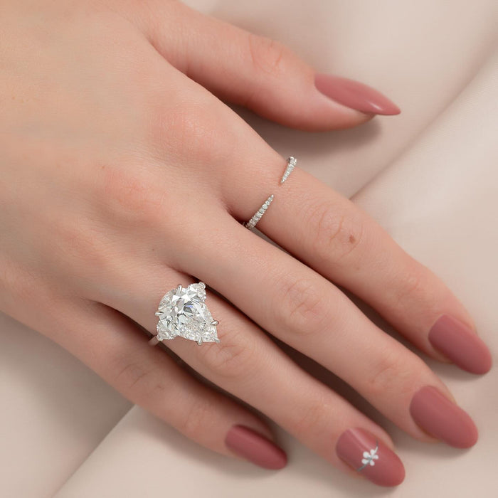 Three stone pear engagement ring worn on the hand