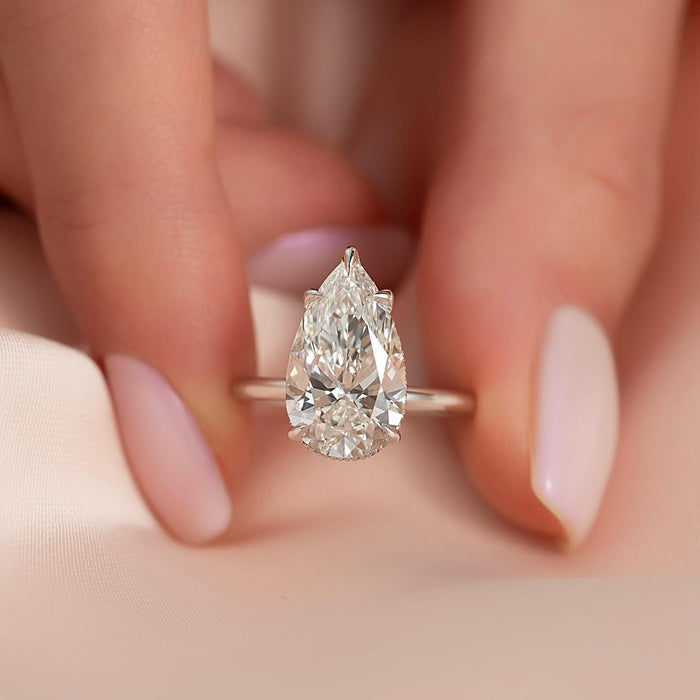 Pear cut diamond set horizontally with the point across the finger