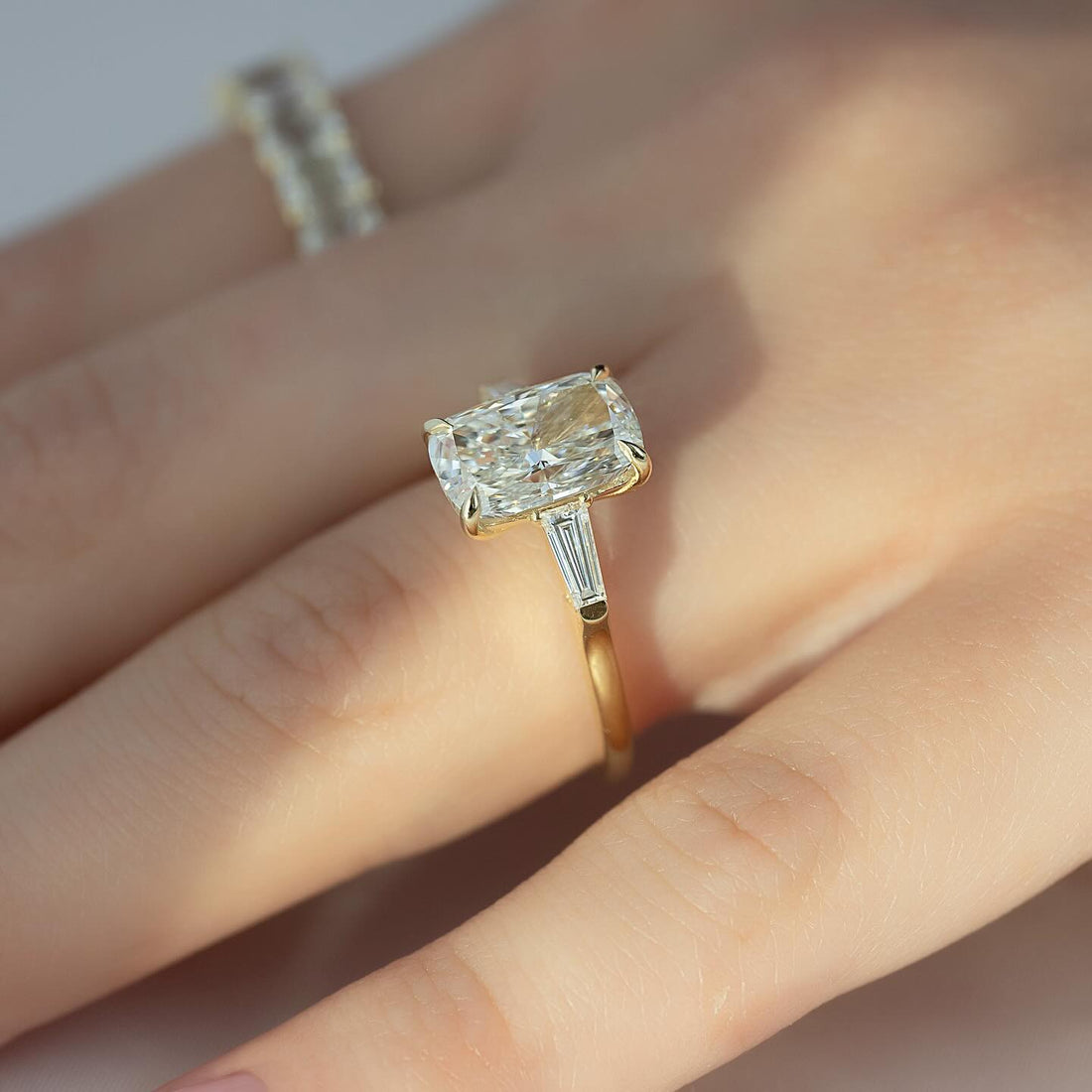 Elongated cushion cut lab grown diamond ring in yellow gold with tapered baguette shoulders