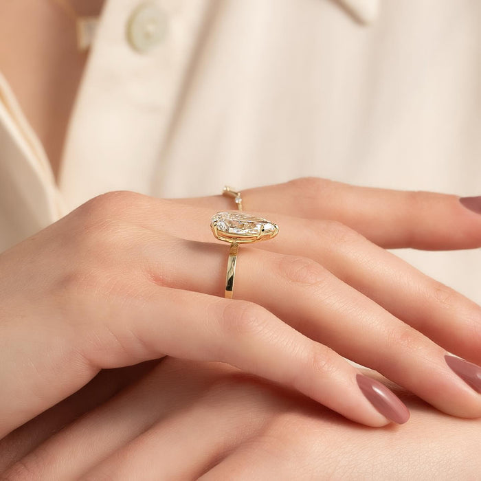 Pear cut lab grown diamond set sideways on a plain flat band