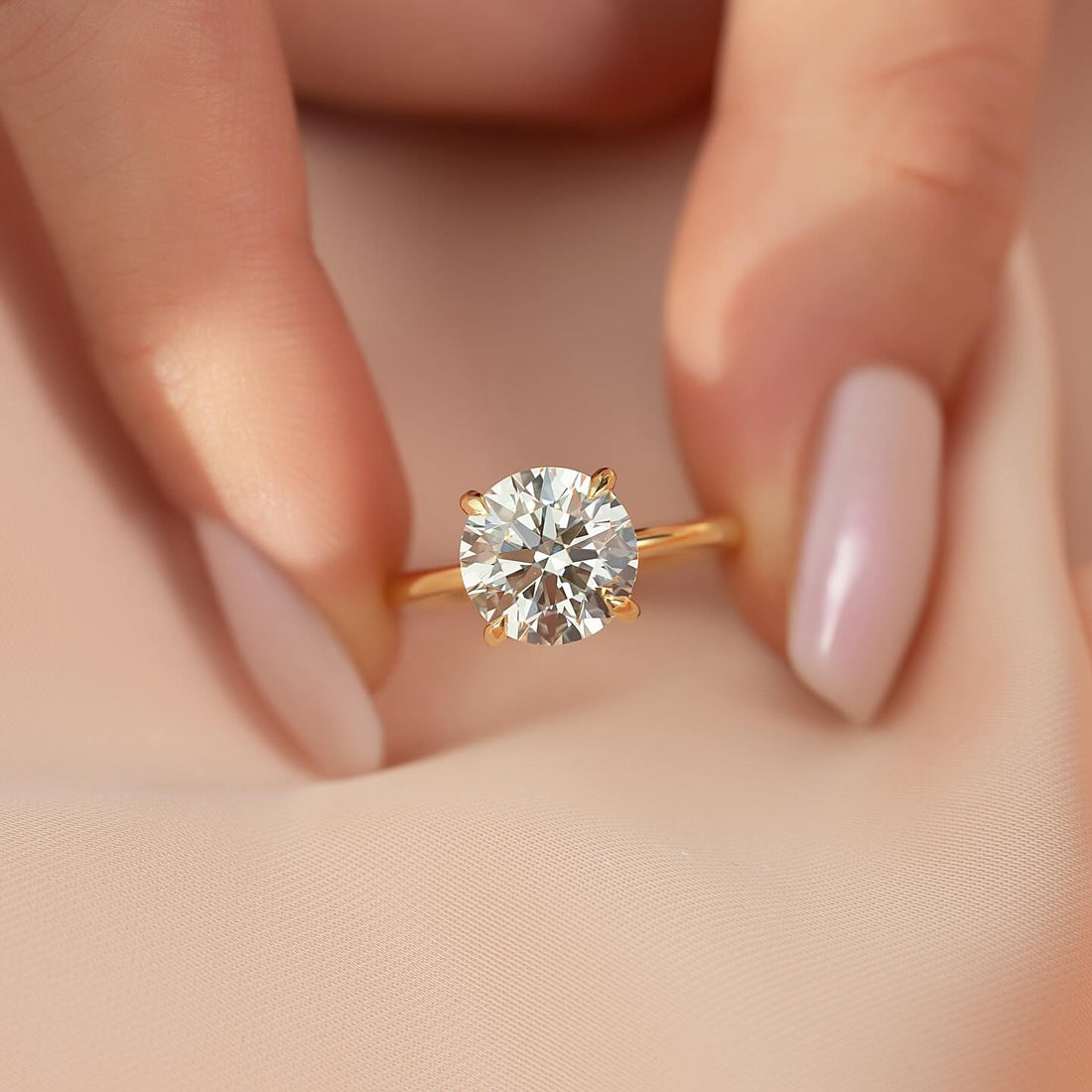 Round brilliant lab grown diamond four prong solitaire ring on a fine yellow gold band