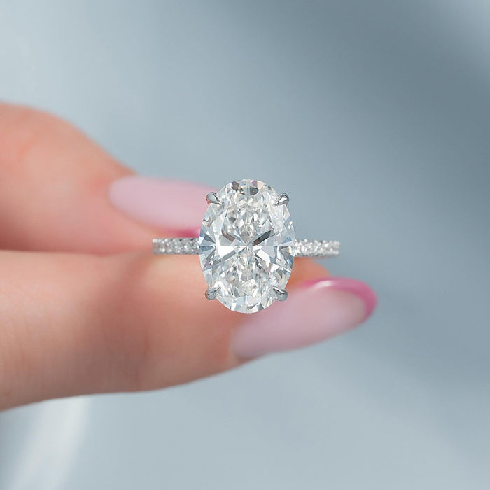 Oval cut lab grown diamond four claw ring on a pave band in white gold, front view