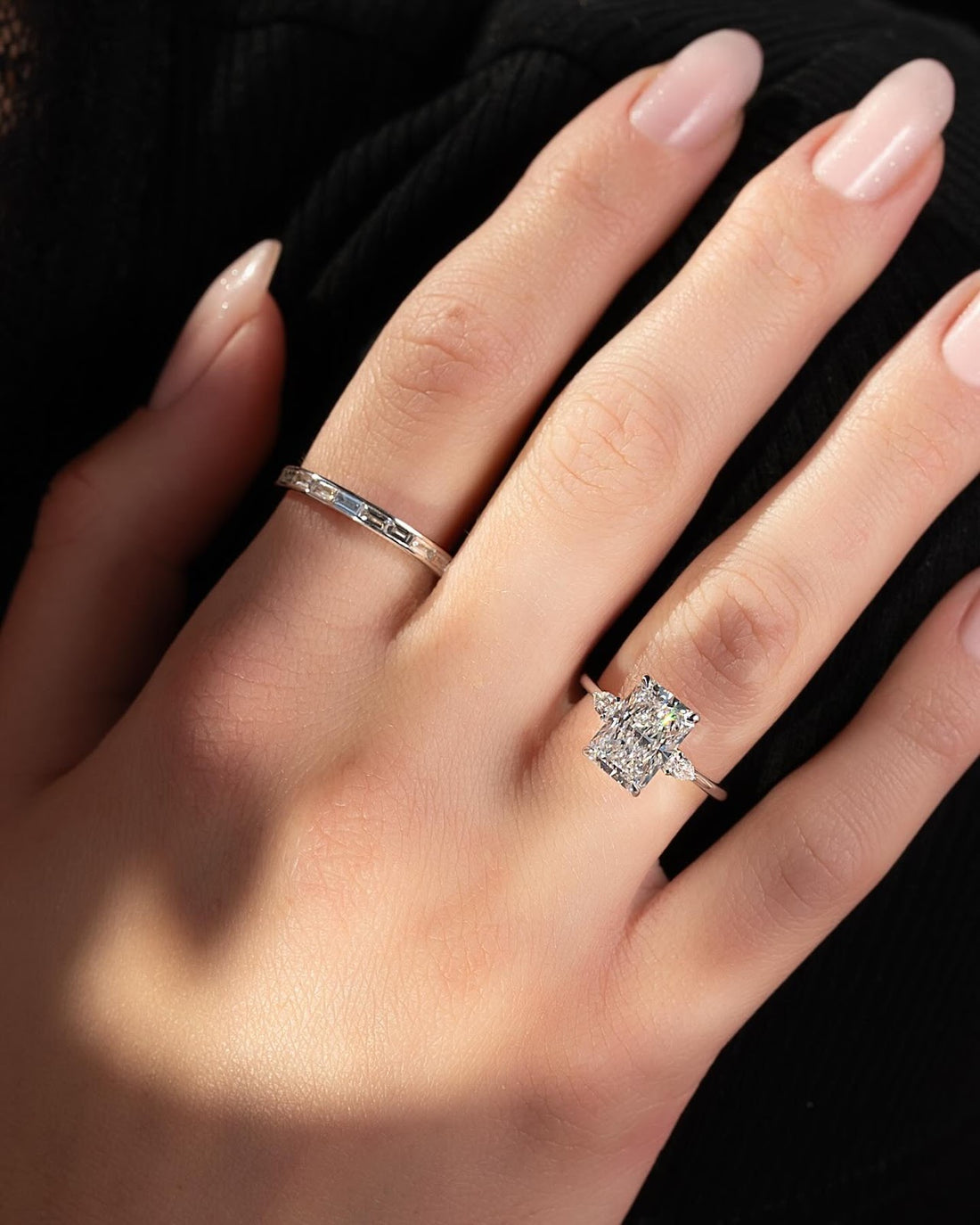 Radiant cut lab grown diamond ring with pear corner accents in white gold worn on the hand