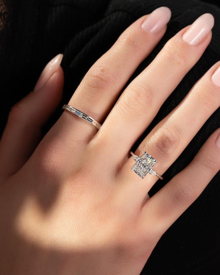 Radiant cut lab grown diamond ring with pear corner accents in white gold worn on the hand