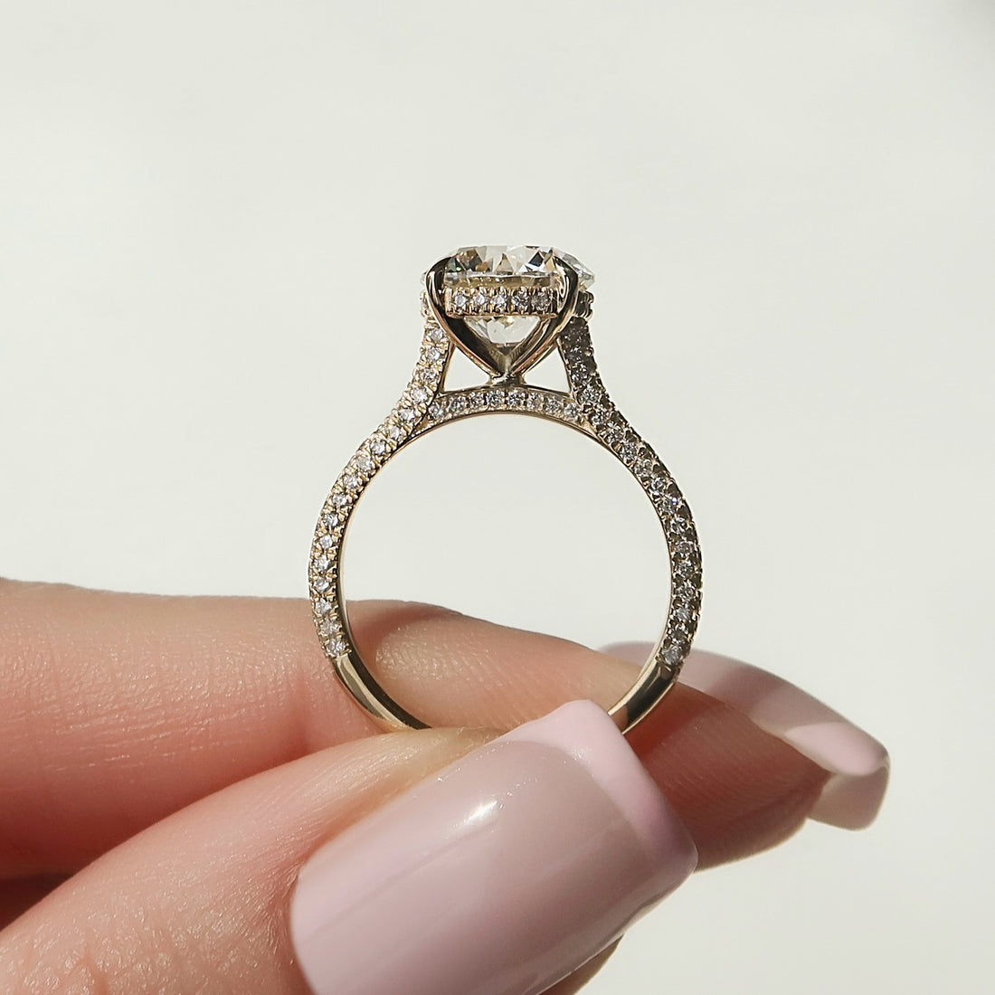 Round lab grown diamond ring with three sided micro pave band and hidden halo in yellow gold