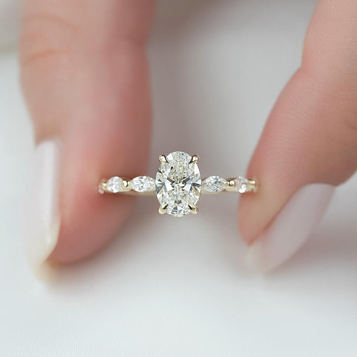 Oval lab grown diamond ring showing the concealed halo and scalloped marquise accent line