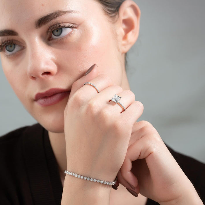 Four corner claws wrapping the points of the princess cut diamond