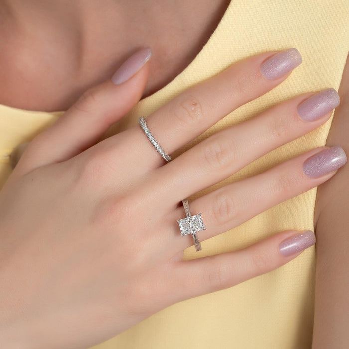 Filigree and milgrain radiant cut engagement ring worn on the hand