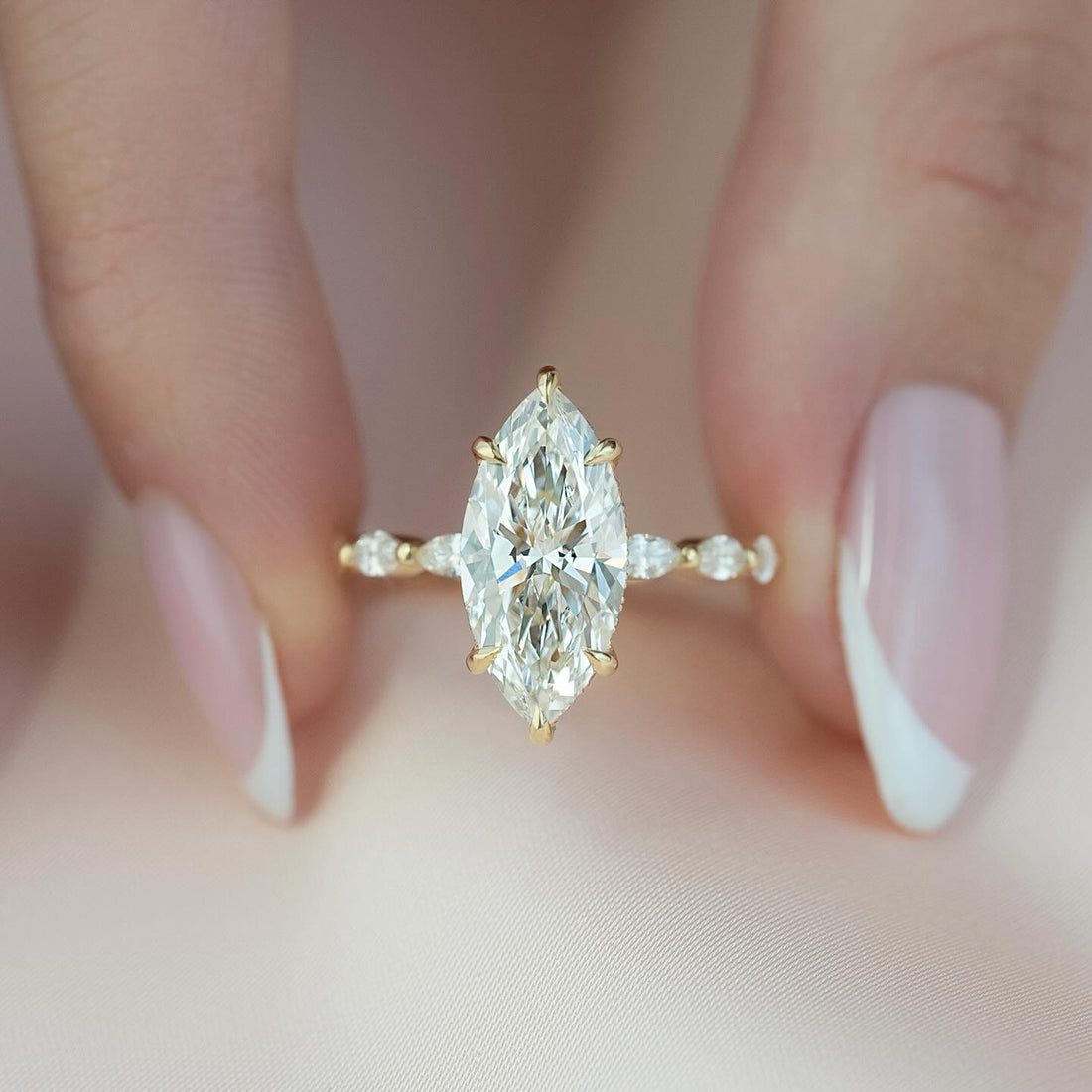 Marquise cut lab grown diamond ring with marquise and round station band in yellow gold
