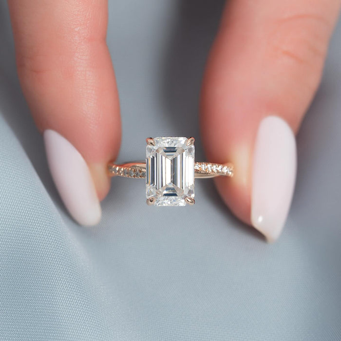 Emerald cut lab grown diamond ring on a twisted pave band in rose gold, front view