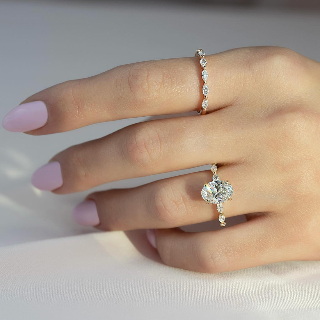 Oval cut lab grown diamond ring with alternating marquise and round spaced accents in yellow gold