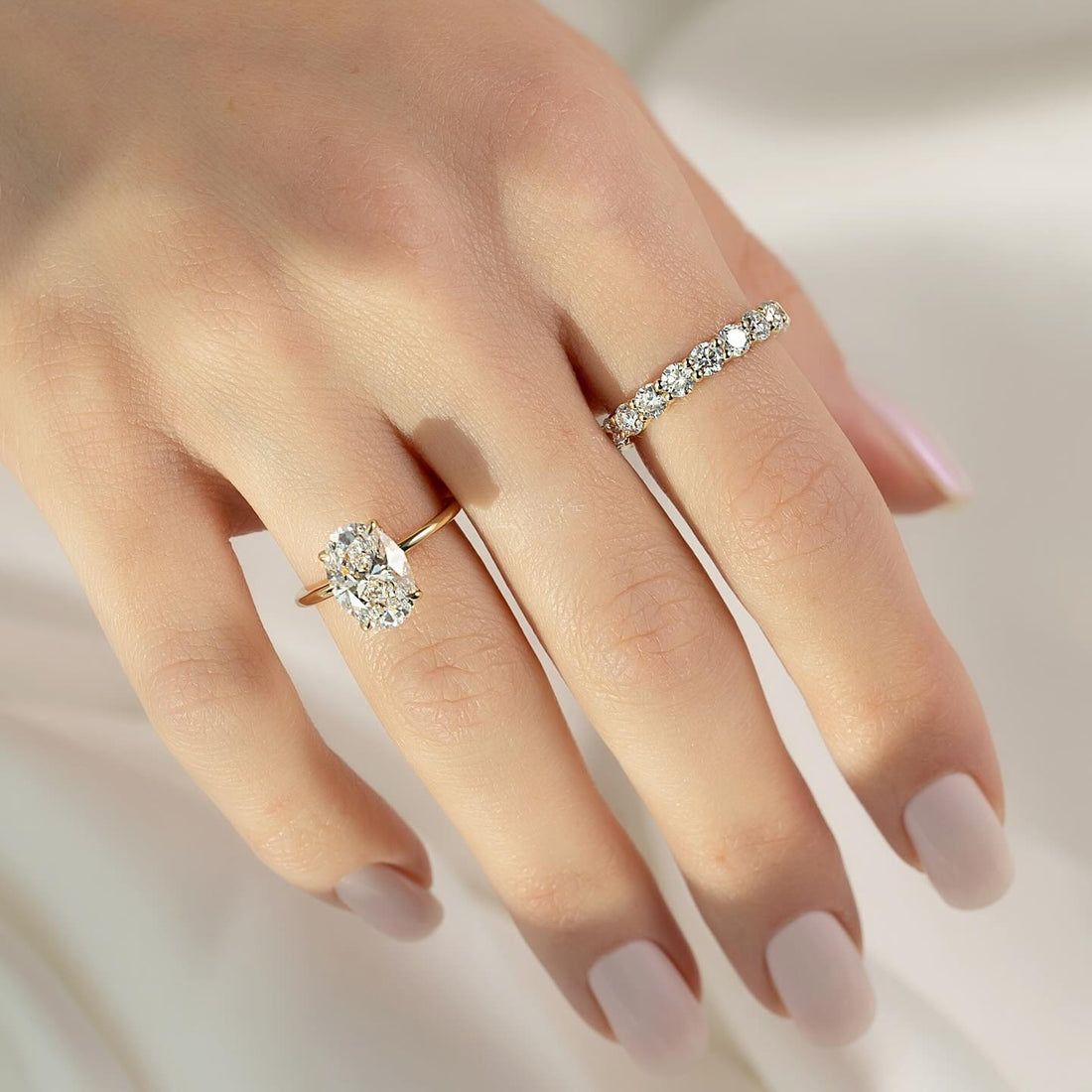 Oval cut lab grown diamond solitaire ring on a plain rounded yellow gold band