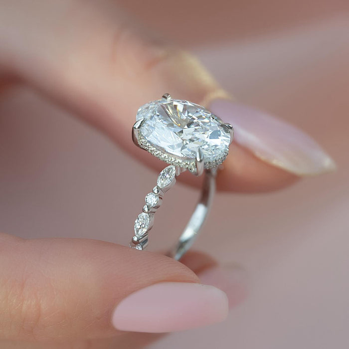 Alternating marquise and round accents along the shoulder of the oval ring