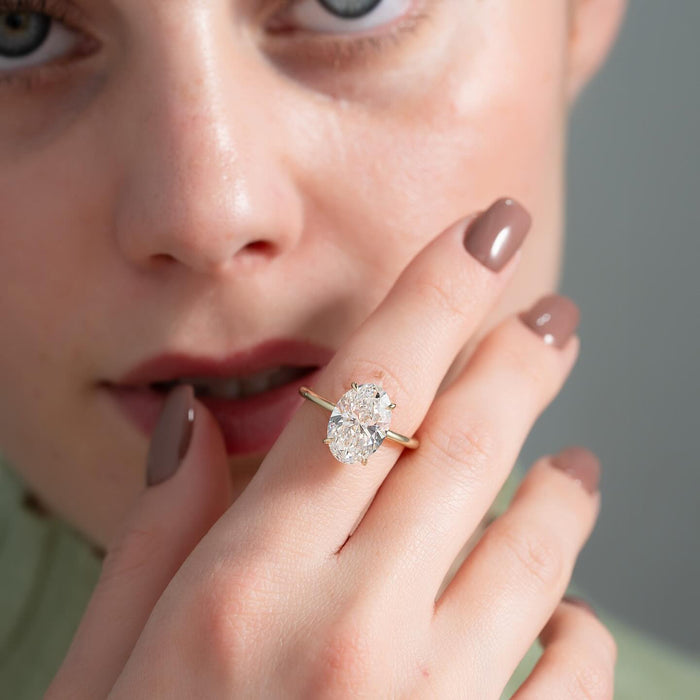 Four slender claws holding the oval lab grown diamond