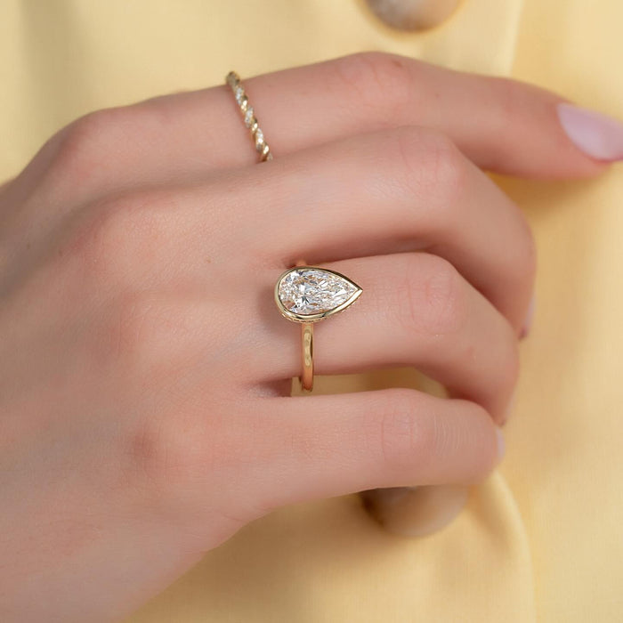 Bezel set pear cut lab grown diamond ring worn on the hand