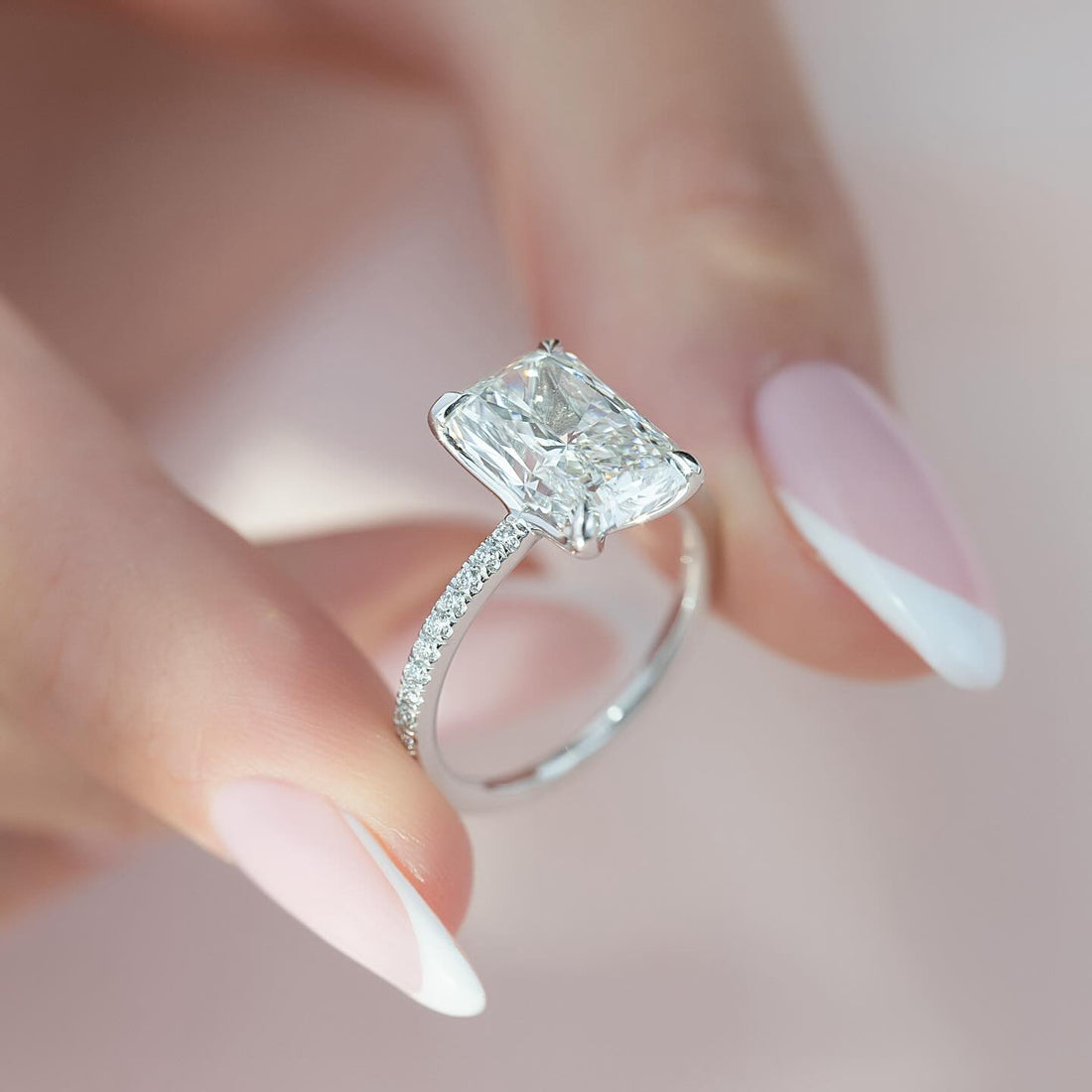 Radiant cut lab grown diamond ring in white gold with corner claws on a half pave shank
