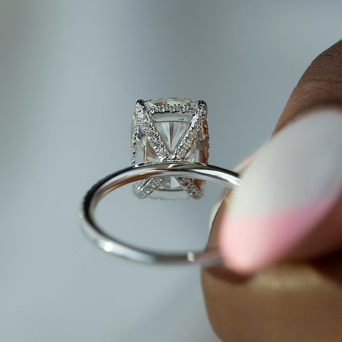 Four claw setting holding the elongated cushion diamond low to the finger