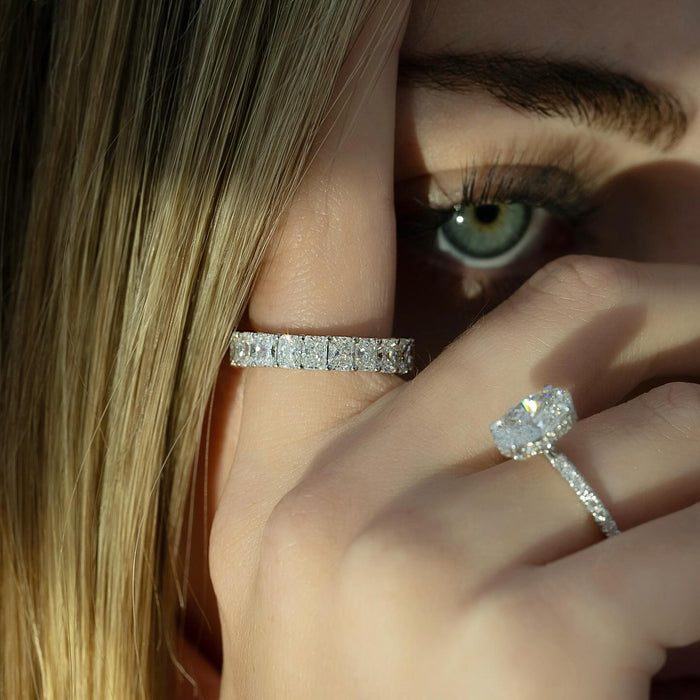 Oval diamond engagement ring with pave band worn on the hand