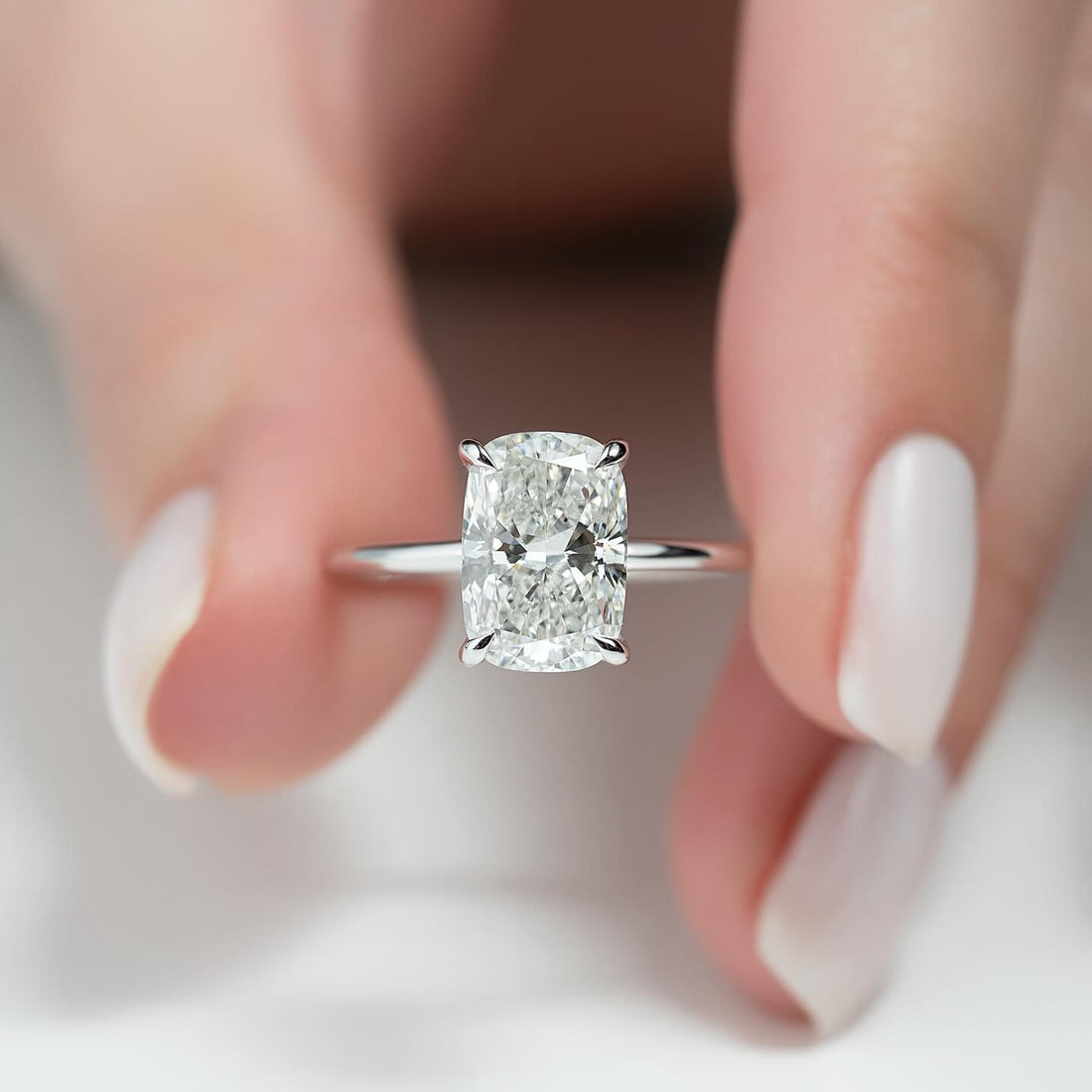 Elongated cushion cut lab grown diamond ring in white gold with a concealed halo