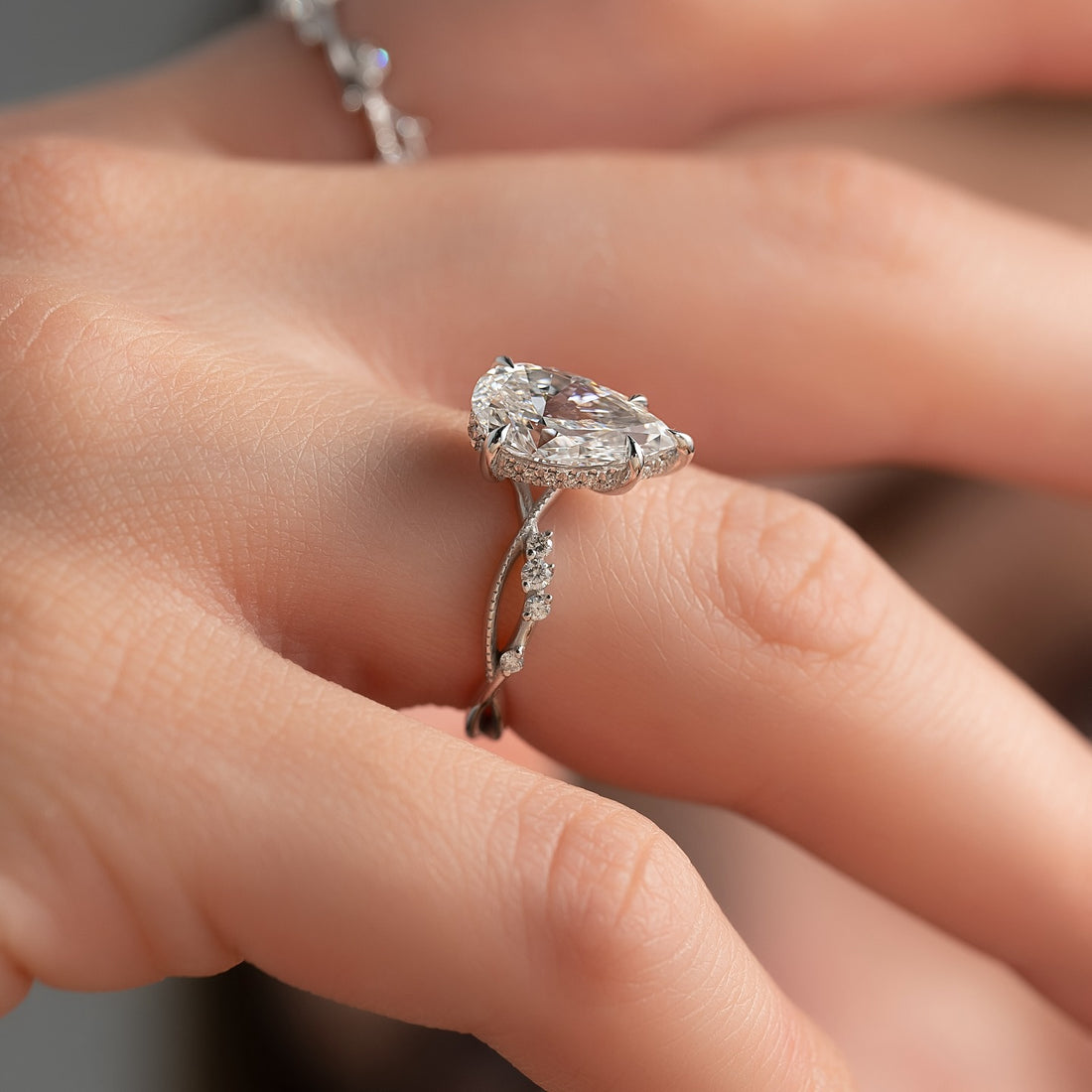 Pear cut lab grown diamond ring with hidden halo on a twisted pave vine band in white gold