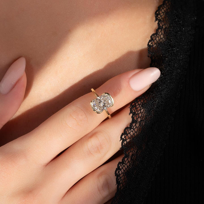 Half bezel cushion diamond engagement ring worn on hand