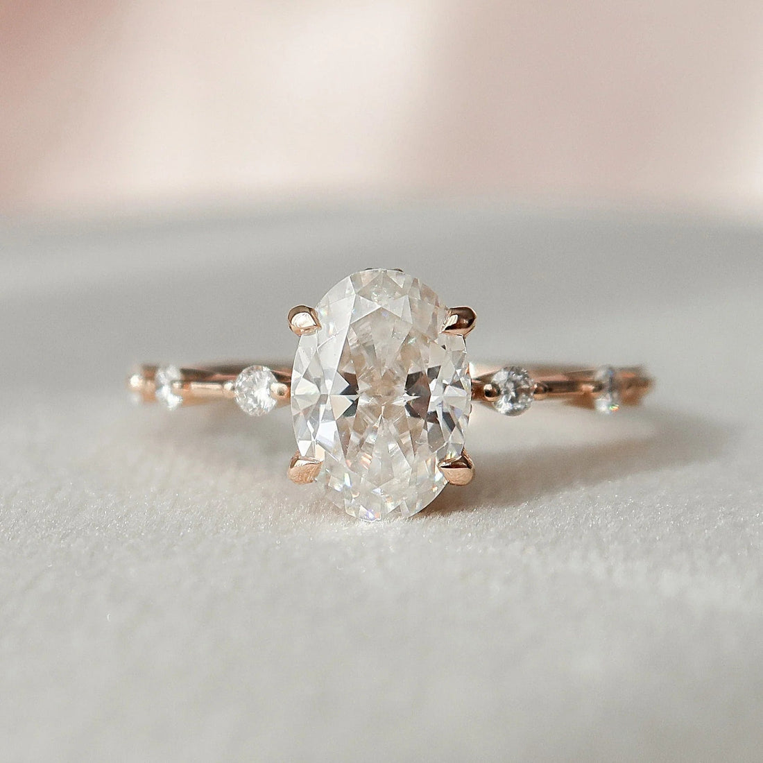 Oval cut moissanite engagement ring with distance pave gold band