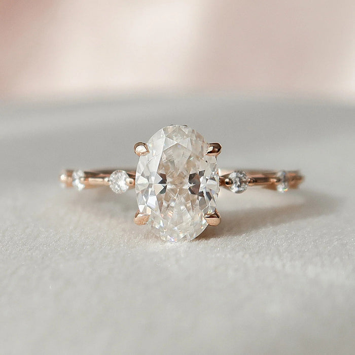 Oval cut moissanite engagement ring with distance pave gold band